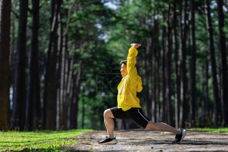 Photo for Trail runner is stretching for warm up outdoor in the pine forest dirt road for exercise and workout activities training for achieving healthy lifestyle and fitness usage - Royalty Free Image