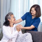 Senior woman get medical service visit from caregiver nurse at home while showing gratitude on appointment for health care and pension welfare insurance
