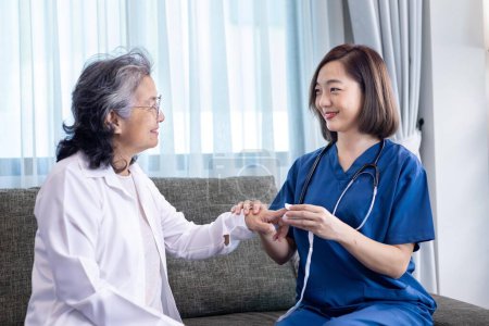 Téléchargez les photos : Une femme âgée reçoit la visite médicale d'une infirmière soignante à domicile alors qu'elle a subi un examen médical à l'oxymètre de pouls pour les soins de santé et l'assurance-retraite - en image libre de droit