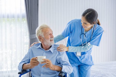 Téléchargez les photos : Un homme caucasien âgé reçoit la visite médicale d'une infirmière soignante à domicile tout en manifestant de la gratitude lors d'un rendez-vous pour le suivi des soins de santé et de l'assurance-retraite - en image libre de droit
