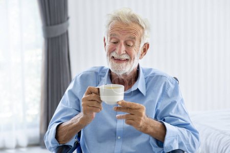 Téléchargez les photos : Homme caucasien âgé boit et profite de sa tisane chaude le matin pour la santé, la longévité et la retraite concept de bonheur - en image libre de droit
