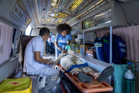 Foto de Team of paramedic is helping the senior patient who is stop breathing from car crash by using respirator for heart attack and street accident - Imagen libre de derechos