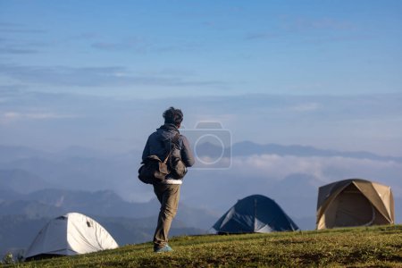 Téléchargez les photos : Voyageur est trekking au sommet de la montagne au camping avec plusieurs tentes parmi les belles vues panoramiques de haute altitude pour les voyages d'aventure de plein air - en image libre de droit