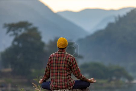 Téléchargez les photos : Vue arrière de l'homme pratique le yoga de méditation en forêt en été pour atteindre le bonheur de la paix intérieure sagesse avec la lumière du matin pour un esprit et une âme sains - en image libre de droit