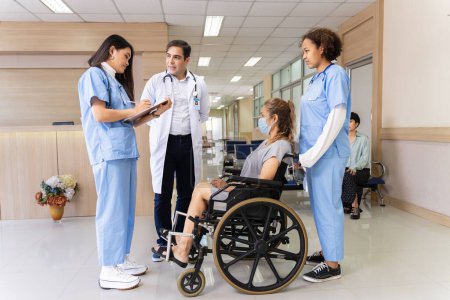 Photo for Team of doctor from different diversity is cheerfully encourage the senior patient with osteoarthritis in wheelchair at her appointment in hospital for physical therapy after knee surgery - Royalty Free Image