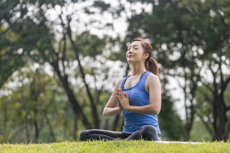 Téléchargez les photos : Jeune femme asiatique en costume de yoga pratiquer la méditation relaxante dans la forêt pour atteindre le bonheur de la paix intérieure sagesse pour l'exercice respiratoire, esprit sain et âme - en image libre de droit
