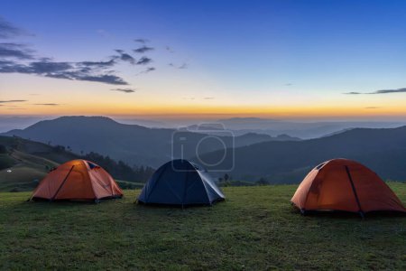 Téléchargez les photos : Groupe de tentes aventurières pendant la nuit camping au beau point de vue panoramique coucher de soleil sur la couche de montagne pour les voyages d'aventure en plein air - en image libre de droit