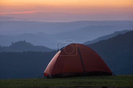 Téléchargez les photos : Tentes d'aventurier pendant la nuit camping au point de vue magnifique coucher de soleil panoramique sur la couche de montagne pour les voyages d'aventure de plein air - en image libre de droit