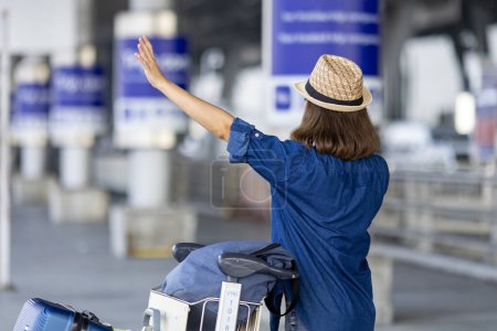 Téléchargez les photos : Femme asiatique voyageuse touristique appelle le taxi de ramassage au terminal de l'aéroport pour le transport pendant son voyage de vacances et long week-end concept de vacances - en image libre de droit