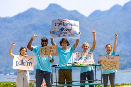 Téléchargez les photos : Une équipe de bénévoles écologistes manifeste au bord de l'océan pour le changement climatique et sauve la nature avec un panneau de protestation contre la pollution et la contamination de la mer pour la protection de la faune et de la biodiversité - en image libre de droit