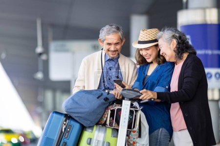 Grupo de pasajeros turísticos familiares asiáticos con adulto mayor está utilizando la aplicación móvil para llamar recoger un taxi en la terminal del aeropuerto para el transporte durante el viaje de vacaciones y largas vacaciones de fin de semana