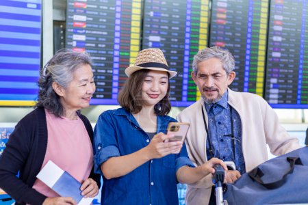 Photo for Group of Asian family tourist passengers with senior parent looking at the departure table at airport terminal for airline travel and holiday vacation - Royalty Free Image