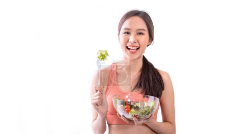 Téléchargez les photos : Femme asiatique en vêtements de sport tenant bol de salade fraîche pour une alimentation saine et la culture végétalienne de l'utilisation de la consommation - en image libre de droit