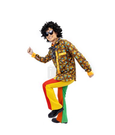 Téléchargez les photos : Asiatique afro hippie homme robe dans les années 80 mode vintage avec des vêtements rétro funk disco coloré tout en dansant isolé sur fond blanc pour la fête de tenue de fantaisie et concept de culture pop - en image libre de droit