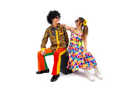 Foto de Vestido de pareja hippie asiático en 80 vintage vestido de moda con colorido retro funk disco ropa mientras baila aislado sobre fondo blanco para la fiesta de disfraces de lujo y la cultura pop - Imagen libre de derechos