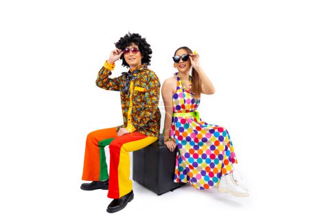 Téléchargez les photos : Robe de couple hippie asiatique dans les années 80 mode robe vintage avec des vêtements rétro funk disco coloré tout en dansant isolé sur fond blanc pour la fête de tenue de fantaisie et la culture pop - en image libre de droit