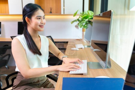 Asiatische Geschäftsfrau im formellen Anzug arbeitet in einem modernen Luxusbüro mit Computer für Wirtschaft und Bildung
