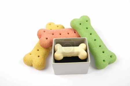 Foto de Huesos de perro y una caja de galletas de perro de presentación sobre un fondo blanco - Imagen libre de derechos