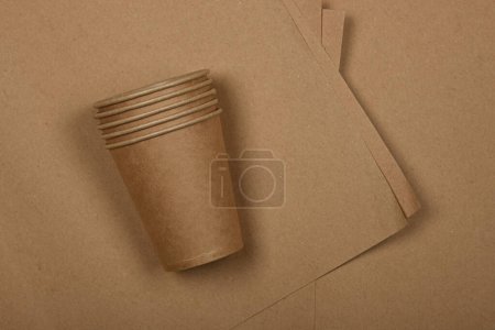 Photo for Close up disposable paper takeaway coffee cups on brown paper background, close up, elevated table top view, directly above - Royalty Free Image