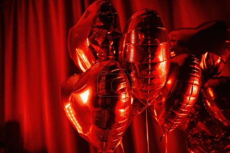 Photo for Extravagant bedroom luxury interior with love glamour decoration at Valentine day in studio. Balloons by heart shaped and at illuminated mirror romantic cozy atmosphere at vivid red background. Beautiful place for st Valentine's holiday - Royalty Free Image