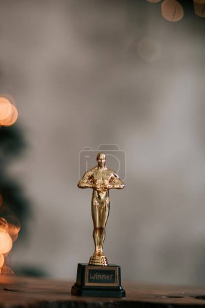 Foto de Hollywood oro oscars trofeo figurilla imitación visto durante una ceremonia de premiación de cine. El éxito y el concepto de victoria se cierran estatuilla en el brillo amarillo luces de fondo - Imagen libre de derechos