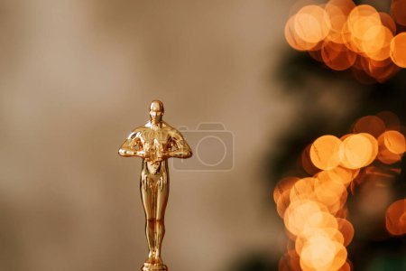 Foto de Hollywood gold oscars trophy figurine imitation seen during an award cinema ceremony. Success and victory concept close up statuette at twinkle yellow lights background - Imagen libre de derechos