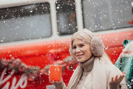 Téléchargez les photos : Souriant actif repos de la femme enceinte se détendre en profitant froid givré temps neigeux en attendant la naissance de l'enfant.Célébration de Noël et du Nouvel An saison des vacances d'hiver à l'extérieur dans la forêt près de Noël vieux bus rouge - en image libre de droit