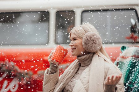 Photo for Smiling active pregnant woman rest relax enjoying cold frosty snowy weather waiting for birth of child.Celebrating Christmas and New Year winter holidays season outside at forest near Xmas red old bus - Royalty Free Image