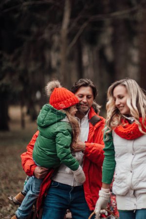 Photo for Happy family celebrating Christmas and New Year winter holidays season outdoor. Active kid with parents joyful spending time together hugging having fun near Xmas bus rejoices at first snow - Royalty Free Image