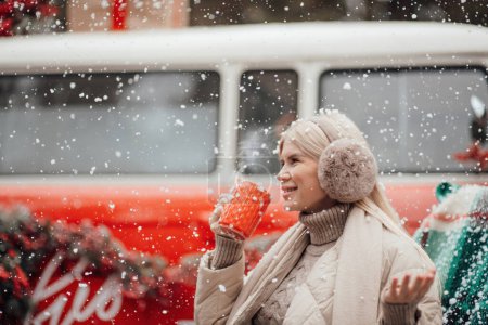 Photo for Smiling active pregnant woman rest relax enjoying cold frosty snowy weather waiting for birth of child.Celebrating Christmas and New Year winter holidays season outside at forest near Xmas red old bus - Royalty Free Image