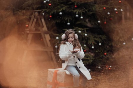 Foto de Niña celebrando Navidad y Año Nuevo vacaciones de invierno temporada al aire libre. Chica activa alegre pasar tiempo en el bosque de coníferas disfrutando de la infancia - Imagen libre de derechos