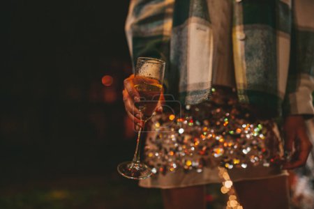 Photo for Girl with sparkling wine in hand celebrating Christmas and New Year winter holidays season outdoor. - Royalty Free Image