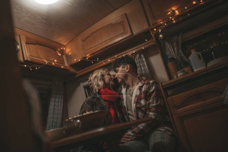 Photo for Happy couple celebrating Christmas and New Year winter holidays season in Camper Park. Young couple spending time together take selfie photo for social media in Xmas camper trailer - Royalty Free Image