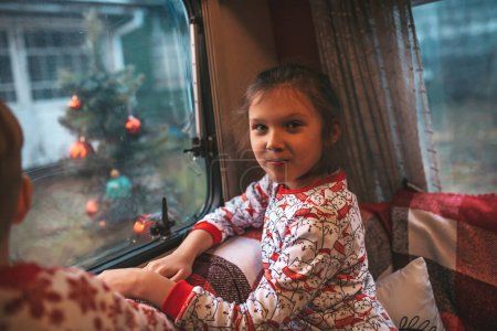 Foto de Niño y niña celebrando Navidad y Año Nuevo vacaciones de invierno temporada de espera de Santa en Navidad caravana remolque. - Imagen libre de derechos