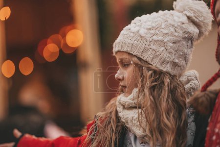 Foto de Niña celebrando Navidad y Año Nuevo vacaciones de invierno temporada al aire libre, esperando Santa cerca de Navidad caravana remolque y se regocija en la primera nieve disfrutando de la infancia - Imagen libre de derechos
