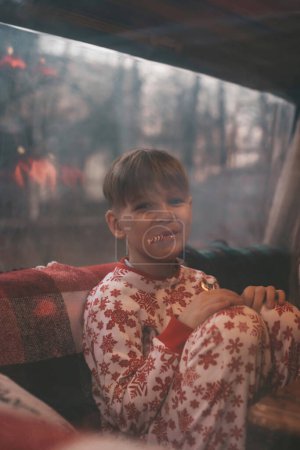 Téléchargez les photos : Petit garçon profitant de la canne à bonbons tout en célébrant Noël et Nouvel An saison des vacances d'hiver attendant le Père Noël au camping-car de Noël remorque - en image libre de droit