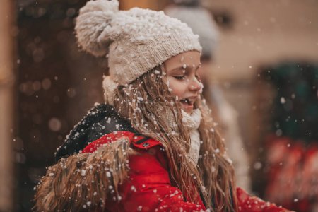 Photo for Little girl celebrating Christmas and New Year winter holidays season outdoor, waiting Santa near Xmas camper trailer and rejoices at first snow enjoying childhood - Royalty Free Image