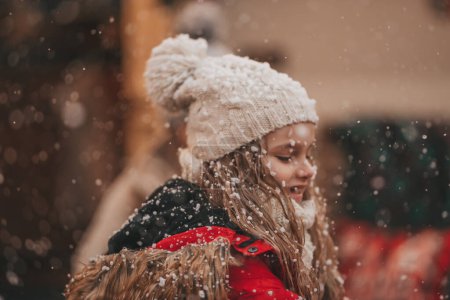 Téléchargez les photos : Petite fille célébrant Noël et Nouvel An saison des vacances d'hiver en plein air, attendant Santa près de caravane camping-car de Noël et se réjouit à la première neige profiter de l'enfance - en image libre de droit