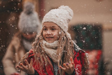 Téléchargez les photos : Filles célébrant Noël et Nouvel An saison des vacances d'hiver en plein air. Petites filles joyeuses passer du temps ensemble près de caravane de Noël. - en image libre de droit