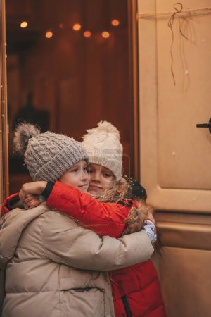Téléchargez les photos : Filles célébrant Noël et Nouvel An saison des vacances d'hiver en plein air. Petites filles joyeuses passer du temps ensemble près de caravane de Noël. - en image libre de droit