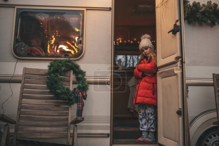 Photo for Little girl celebrating Christmas and New Year winter holidays season and waiting Santa at Xmas camper trailer. - Royalty Free Image