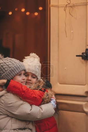 Photo for Girls celebrating Christmas and New Year winter holidays season in camper. Little girls joyful spending time together grimace whispering secrets in ear at Xmas camper trailer enjoying childhood - Royalty Free Image