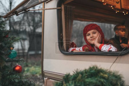 Photo for Children celebrating Christmas and New Year winter holidays season waiting Santa. Kids joyful spending time together at Xmas camper trailer rejoices at first snow enjoying childhood - Royalty Free Image