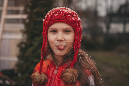 Photo for Little girl celebrating Christmas and New Year winter holidays season outdoor, waiting Santa near Xmas camper trailer and rejoices at first snow enjoying childhood - Royalty Free Image