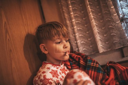 Photo for Little boy enjoy candy cane while celebrating Christmas and New Year winter holidays season and waiting Santa at Xmas camper trailer. - Royalty Free Image