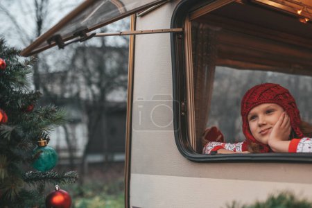 Foto de Niña celebrando Navidad y Año Nuevo temporada de vacaciones de invierno y esperando a Santa en Navidad caravana remolque - Imagen libre de derechos