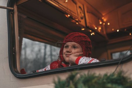 Téléchargez les photos : Fille célébrant Noël et Nouvel An saison des vacances d'hiver attendant le Père Noël au camping-car de Noël remorque. - en image libre de droit