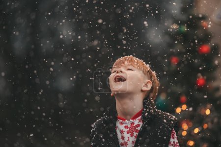 Téléchargez les photos : Petit garçon célébrant Noël et Nouvel An saison des vacances d'hiver en plein air, attendant Santa près de caravane camping-car de Noël et se réjouit à la première neige profiter de l'enfance - en image libre de droit