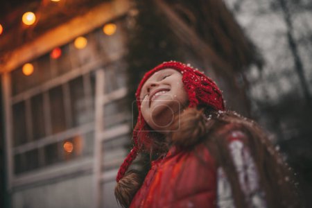 Foto de Chica celebrando Navidad y Año Nuevo vacaciones de invierno temporada al aire libre esperando Santa cerca de Navidad caravana remolque se regocija en la primera nieve disfrutando de la infancia - Imagen libre de derechos