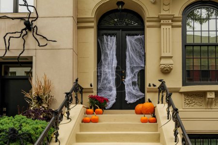 Des décorations d'Halloween assorties gardent les marches avant d'une maison. Des citrouilles sur un porche. Photo de haute qualité
